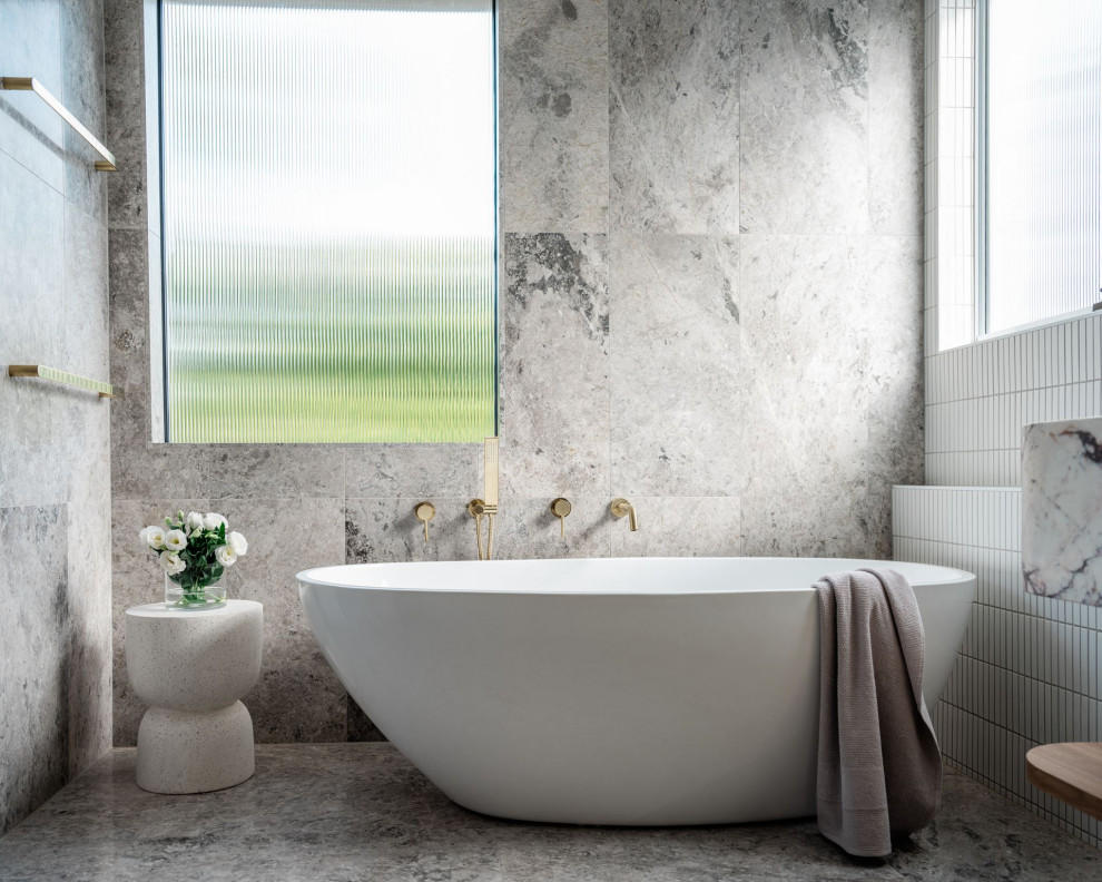Пример оригинального дизайна: главная ванная комната среднего размера в современном стиле с отдельно стоящей ванной, серой плиткой, мраморной плиткой, мраморным полом, серым полом и подвесной тумбой