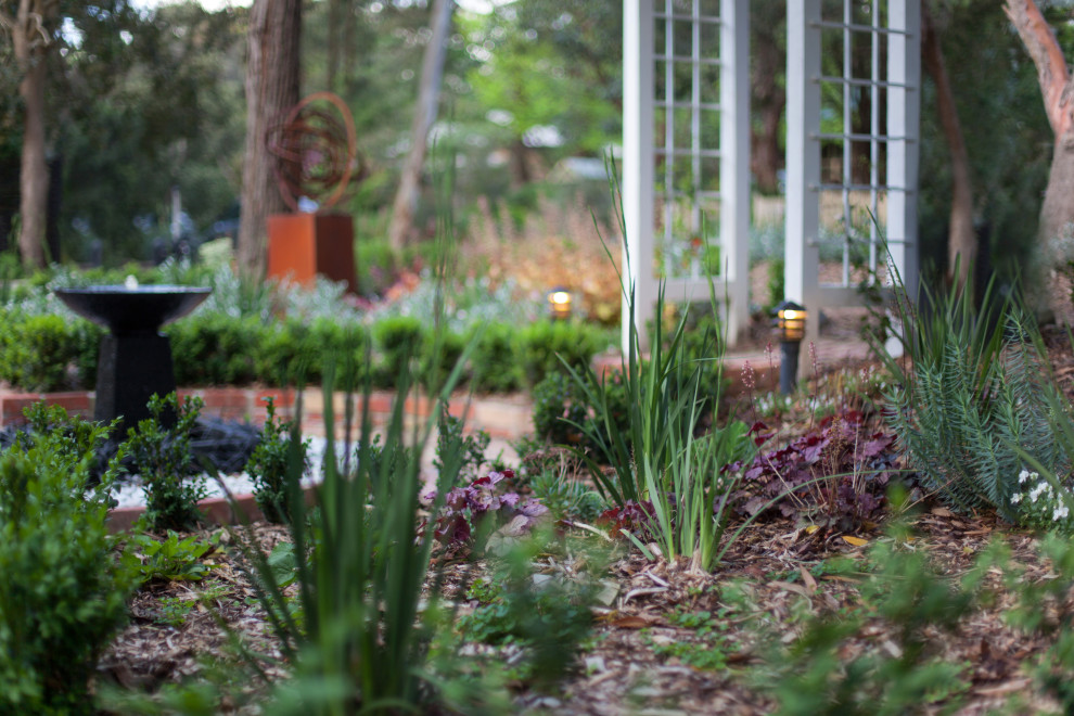 Ispirazione per un ampio giardino minimal esposto in pieno sole davanti casa in primavera con un muro di contenimento, recinzione in legno e pavimentazioni in mattoni