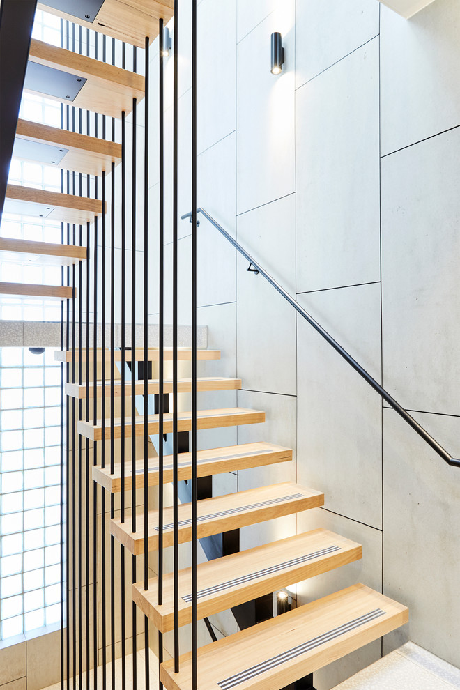 Inspiration for an expansive industrial wood u-shaped staircase in Melbourne with open risers and metal railing.