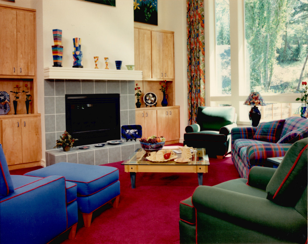 На фото: большая двухуровневая гостиная комната в современном стиле с желтыми стенами, ковровым покрытием, стандартным камином, фасадом камина из плитки, скрытым телевизором, красным полом и сводчатым потолком с