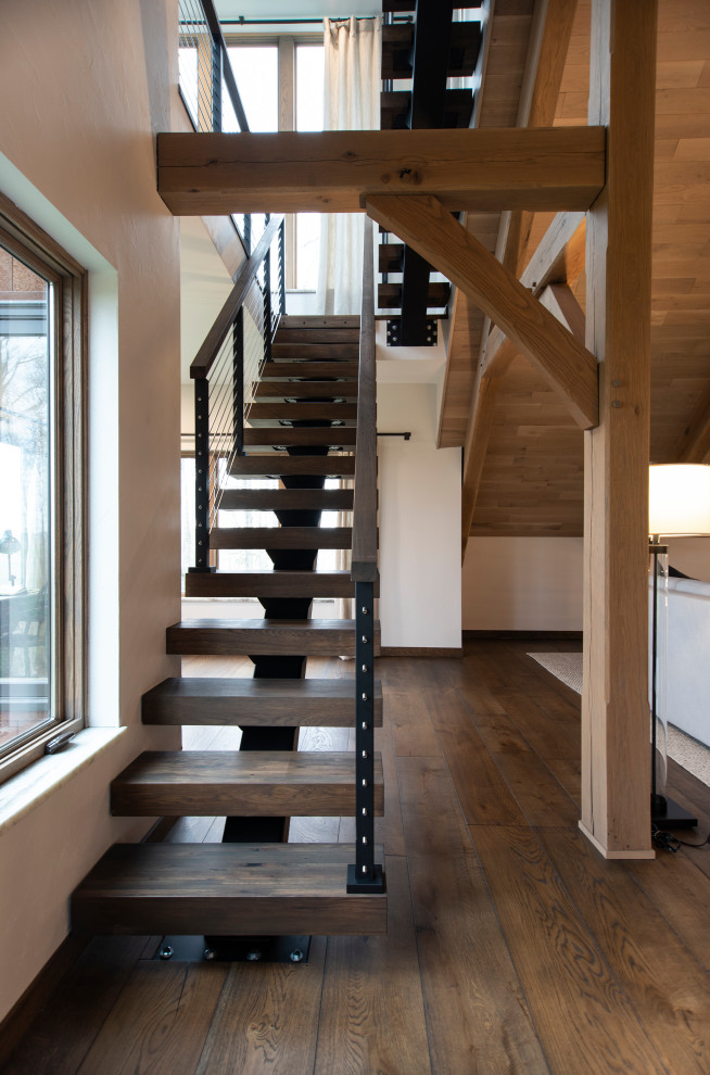 Example of a mountain style wooden floating open and mixed material railing staircase design