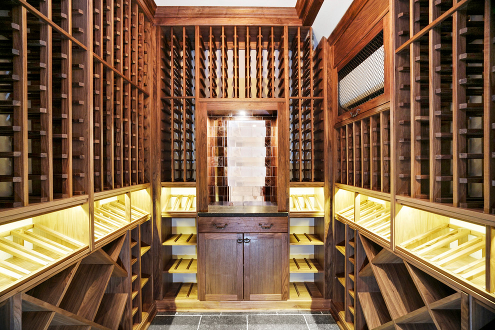 Design ideas for a mid-sized transitional wine cellar in New York with limestone floors.