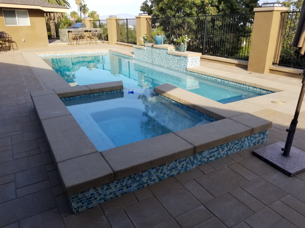 Esempio di una piscina naturale stile marinaro personalizzata di medie dimensioni e dietro casa con pavimentazioni in mattoni