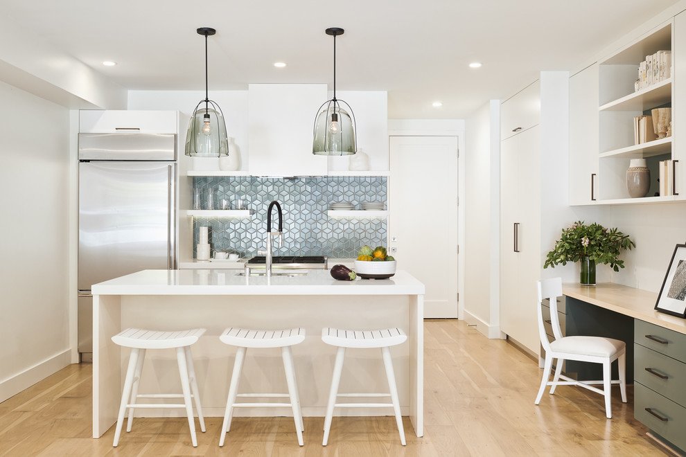 Design ideas for a large transitional galley open plan kitchen in San Francisco with an undermount sink, flat-panel cabinets, white cabinets, quartz benchtops, blue splashback, ceramic splashback, stainless steel appliances, light hardwood floors, with island, white benchtop and brown floor.