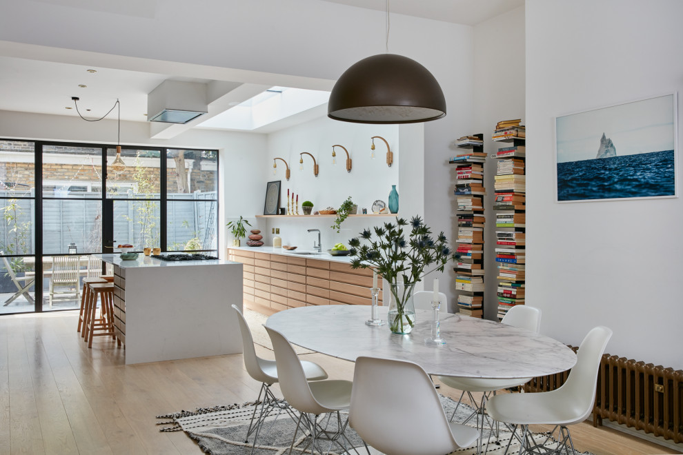 Photo of a mid-sized scandinavian open plan kitchen in London with solid surface benchtops and with island.