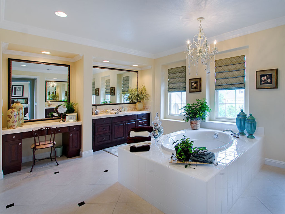 Inspiration for a traditional bathroom in San Diego with raised-panel cabinets, dark wood cabinets, tile benchtops, a drop-in tub and white tile.