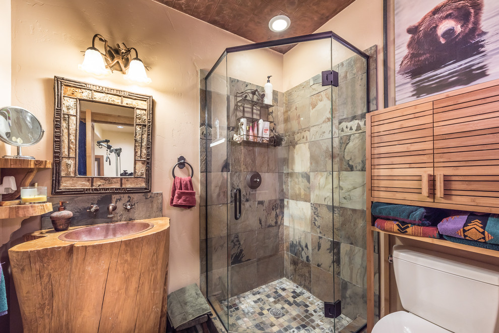 Mid-sized country 3/4 bathroom in Denver with a corner shower, a two-piece toilet, beige tile, brown tile, ceramic tile, beige walls, a drop-in sink, wood benchtops, a hinged shower door and brown benchtops.