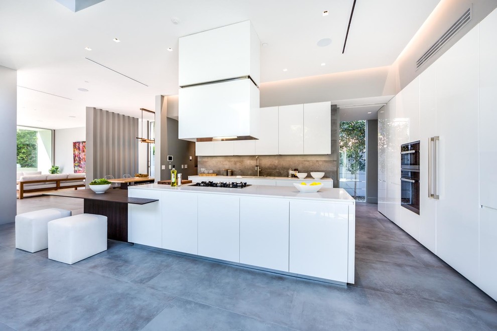 Design ideas for an expansive contemporary l-shaped open plan kitchen in Paris with a single-bowl sink, quartzite benchtops, grey splashback, stone tile splashback, black appliances, ceramic floors, with island and grey floor.
