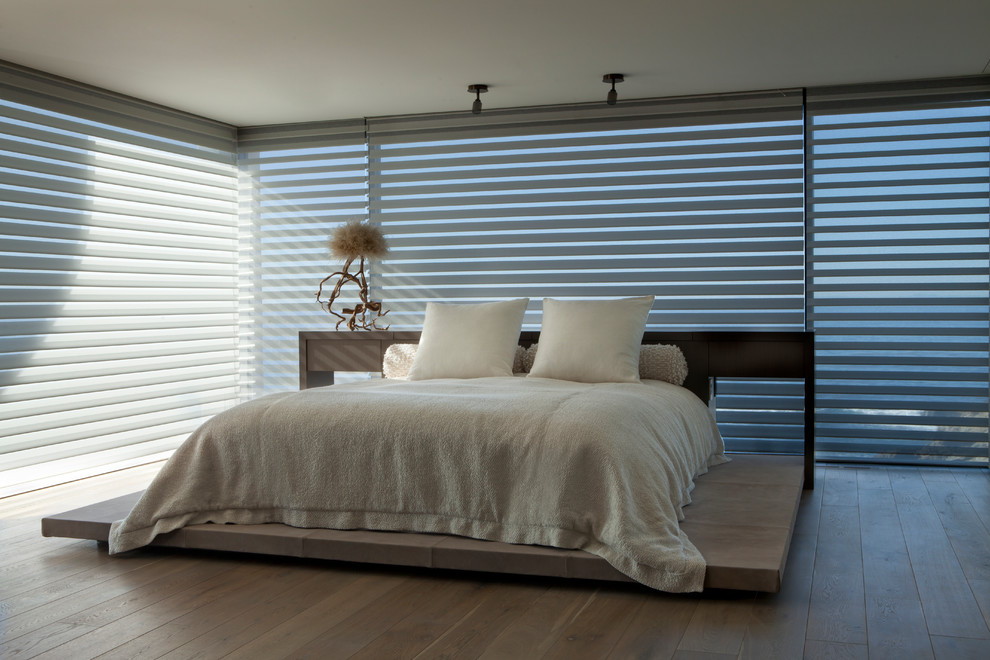 Inspiration for an expansive contemporary master bedroom in Orange County with white walls and medium hardwood floors.
