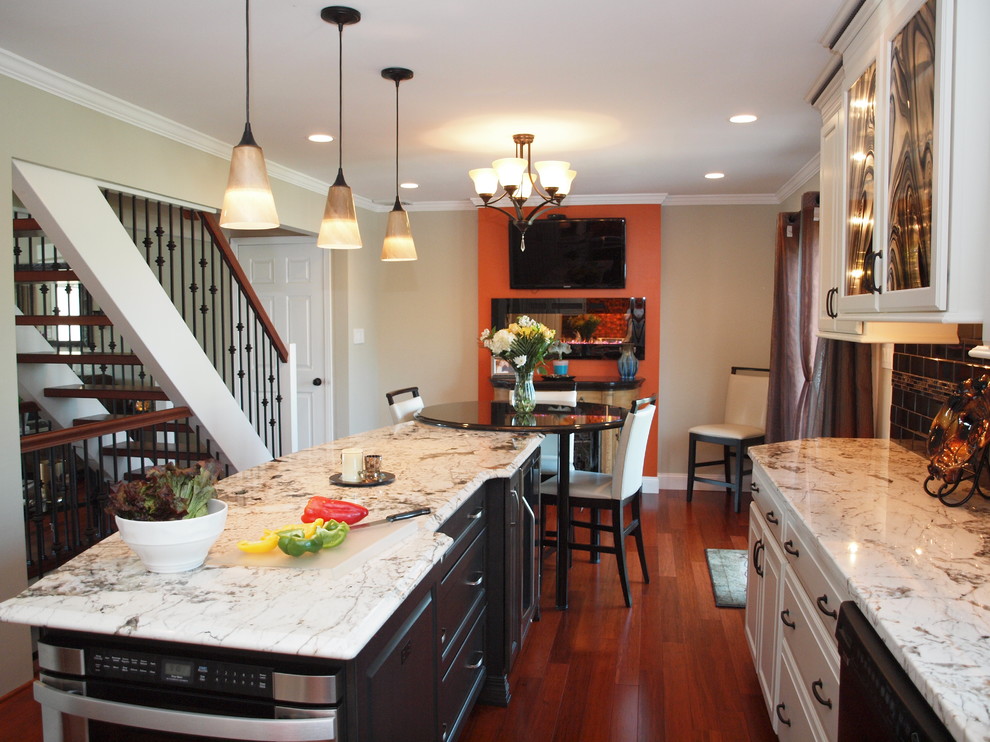 Inspiration for a large transitional medium tone wood floor and brown floor kitchen remodel in Philadelphia with raised-panel cabinets, white cabinets, granite countertops, black backsplash, subway tile backsplash, stainless steel appliances and an island