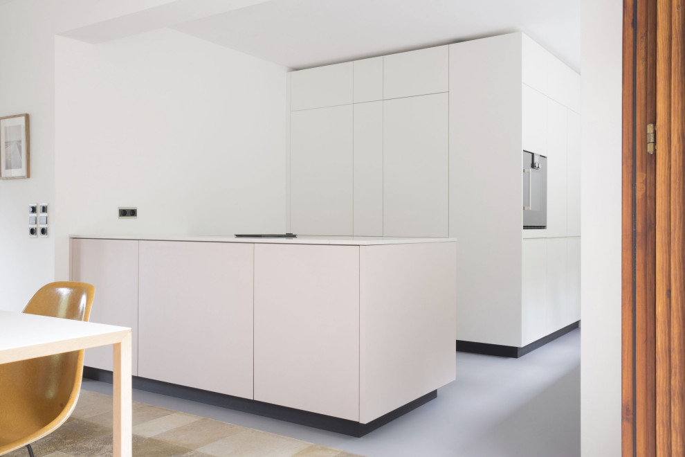 Inspiration for a large modern galley eat-in kitchen in Berlin with a drop-in sink, flat-panel cabinets, pink cabinets, quartz benchtops, white splashback, window splashback, panelled appliances, linoleum floors, with island, grey floor and white benchtop.