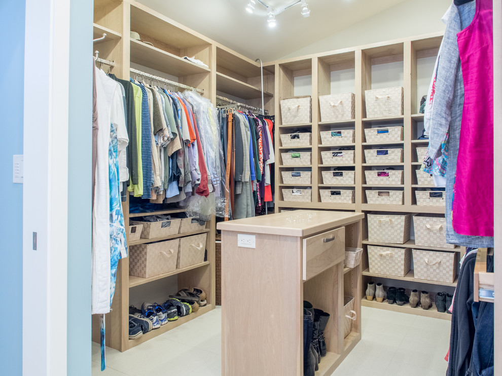 This is an example of a mid-sized transitional gender-neutral walk-in wardrobe in Seattle with flat-panel cabinets, grey cabinets, ceramic floors, beige floor and vaulted.