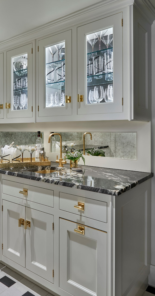 Mid-sized contemporary single-wall wet bar in Chicago with an undermount sink, glass-front cabinets, white cabinets, marble benchtops, white splashback, mirror splashback, ceramic floors, black floor and black benchtop.