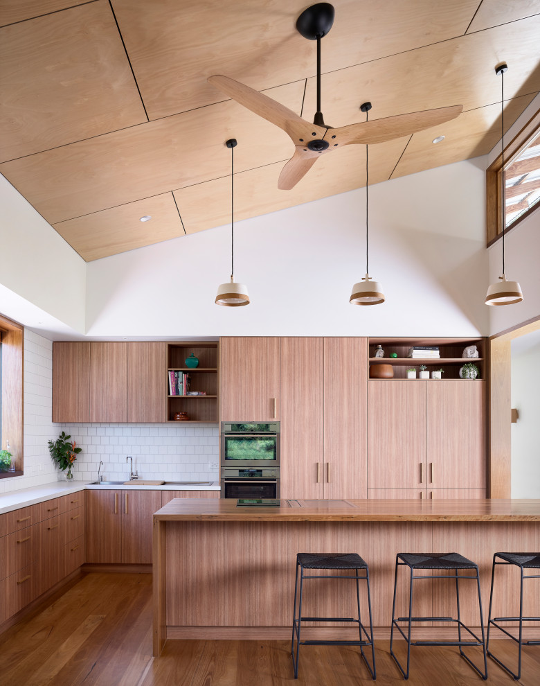 Exempel på ett mellanstort modernt grå grått kök, med en dubbel diskho, öppna hyllor, skåp i mellenmörkt trä, bänkskiva i betong, vitt stänkskydd, stänkskydd i keramik, rostfria vitvaror, ljust trägolv och en köksö