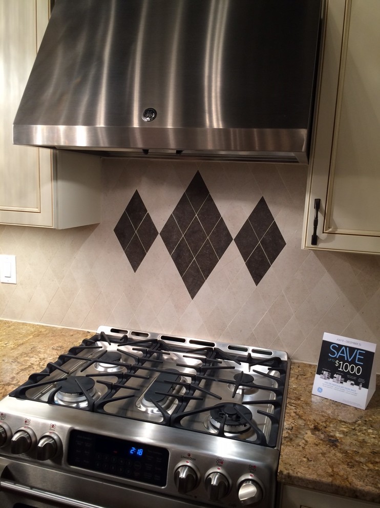 Example of a small classic l-shaped home design design with recessed-panel cabinets, white cabinets, granite countertops, beige backsplash, porcelain backsplash, stainless steel appliances and a peninsula