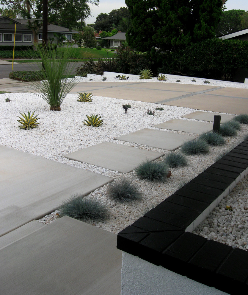 Photo of a mid-sized midcentury front yard full sun xeriscape in Orange County with concrete pavers.