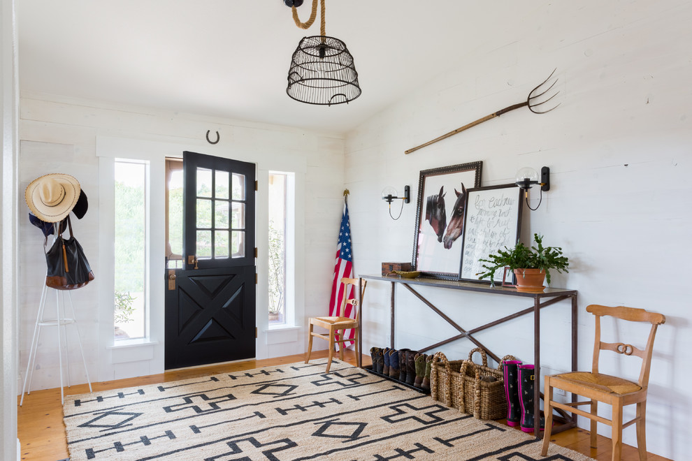 Design ideas for a mid-sized country foyer in Santa Barbara with white walls, light hardwood floors, a dutch front door and a black front door.