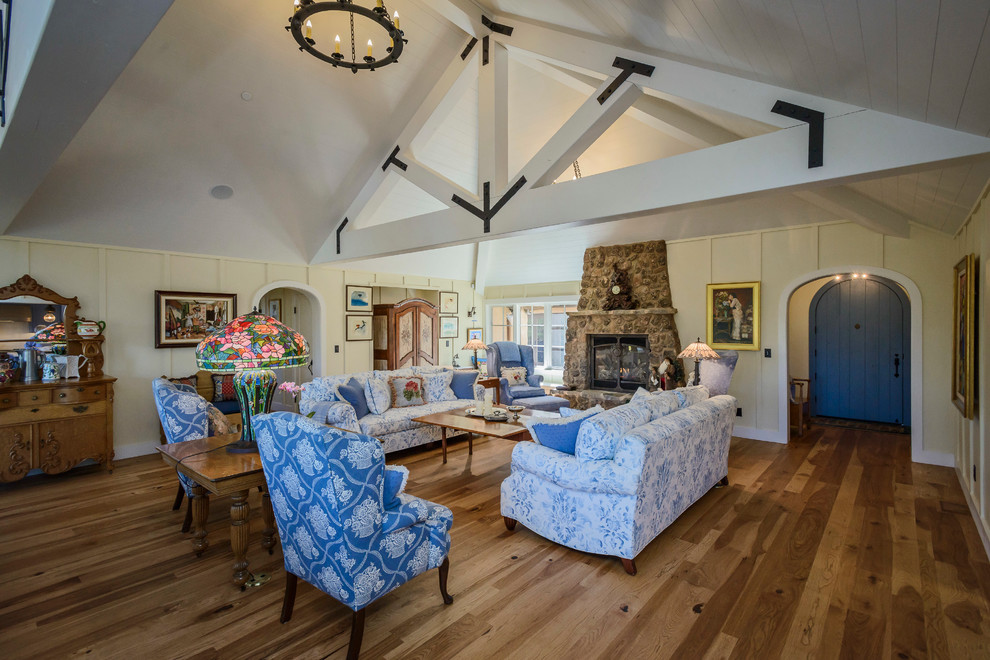 Photo of a mid-sized country formal open concept living room in San Francisco with medium hardwood floors, a standard fireplace, a stone fireplace surround, yellow walls, no tv and brown floor.