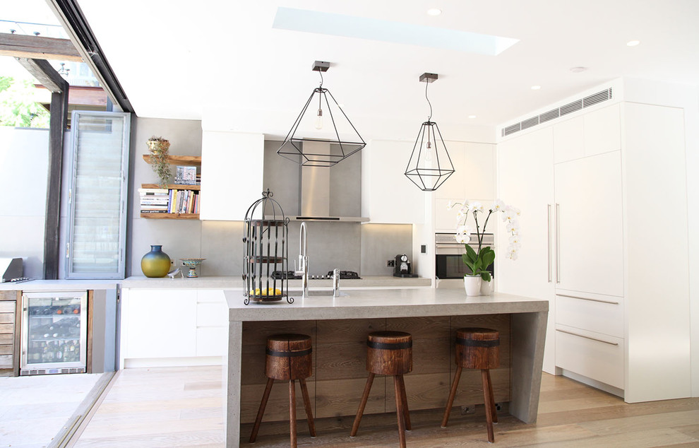 Contemporary kitchen in Sydney with a double-bowl sink, concrete benchtops, grey splashback, stainless steel appliances, light hardwood floors and with island.