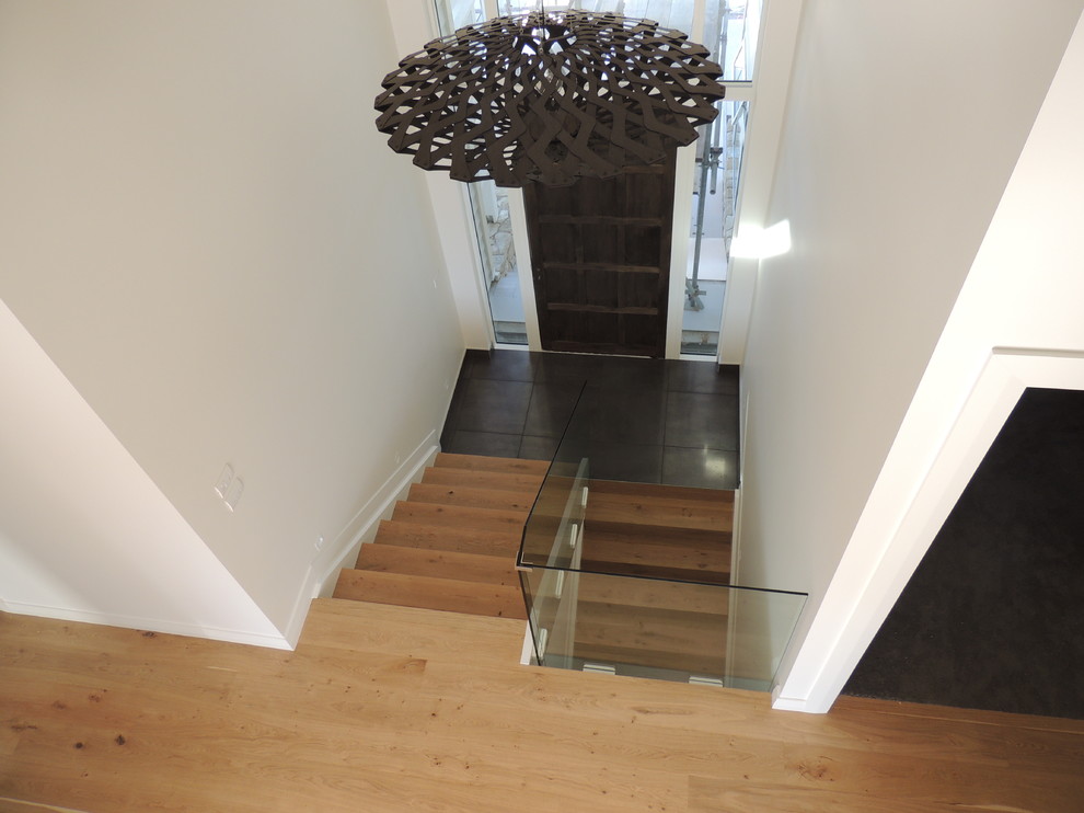 Photo of an expansive contemporary foyer in Auckland with white walls, ceramic floors, a pivot front door and a brown front door.