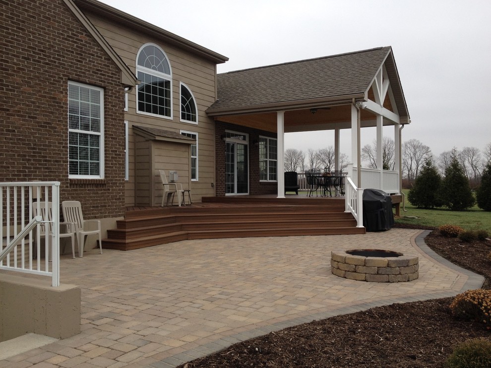 This is an example of a large eclectic backyard patio in Cincinnati with a fire feature and brick pavers.