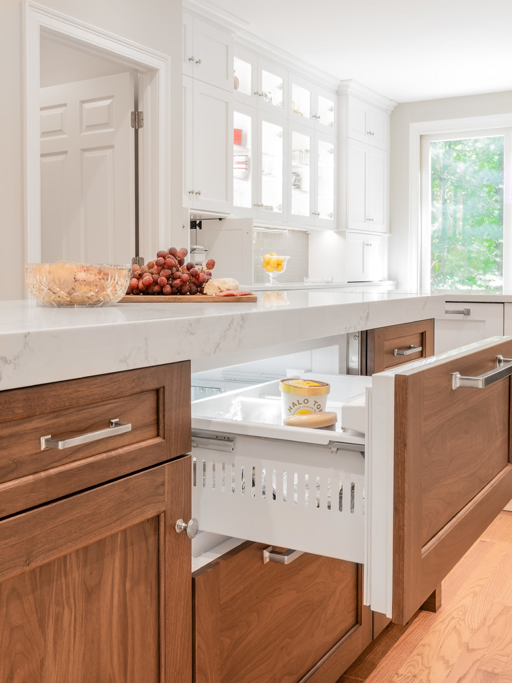 Transitional u-shaped eat-in kitchen photo in Providence with an undermount sink, white cabinets, quartzite countertops, glass tile backsplash, stainless steel appliances and an island