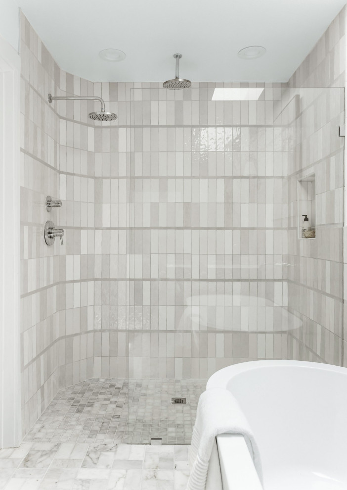 Foto på ett mycket stort maritimt vit en-suite badrum, med skåp i shakerstil, svarta skåp, ett fristående badkar, en kantlös dusch, flerfärgad kakel, stenkakel, vita väggar, marmorgolv, ett undermonterad handfat, bänkskiva i kvartsit, beiget golv och dusch med gångjärnsdörr