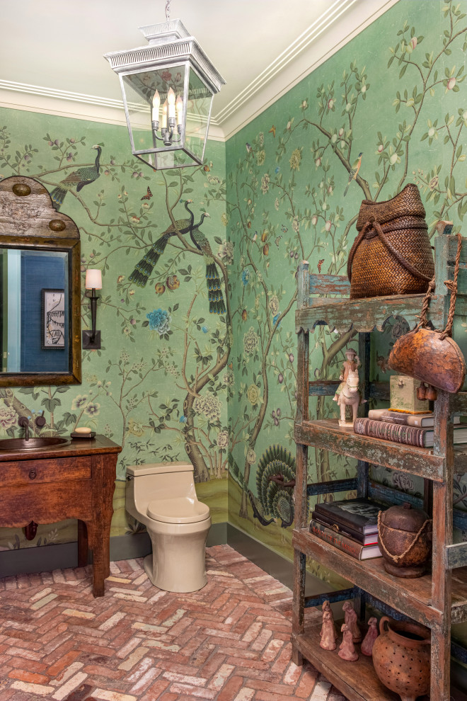 This is an example of an eclectic powder room in New York with furniture-like cabinets, dark wood cabinets, green walls, brick floors, a drop-in sink, wood benchtops, red floor and brown benchtops.