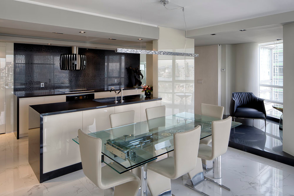 Small modern galley open plan kitchen in Vancouver with flat-panel cabinets, black splashback, with island, an undermount sink, beige cabinets, solid surface benchtops, glass sheet splashback, stainless steel appliances, marble floors and white floor.