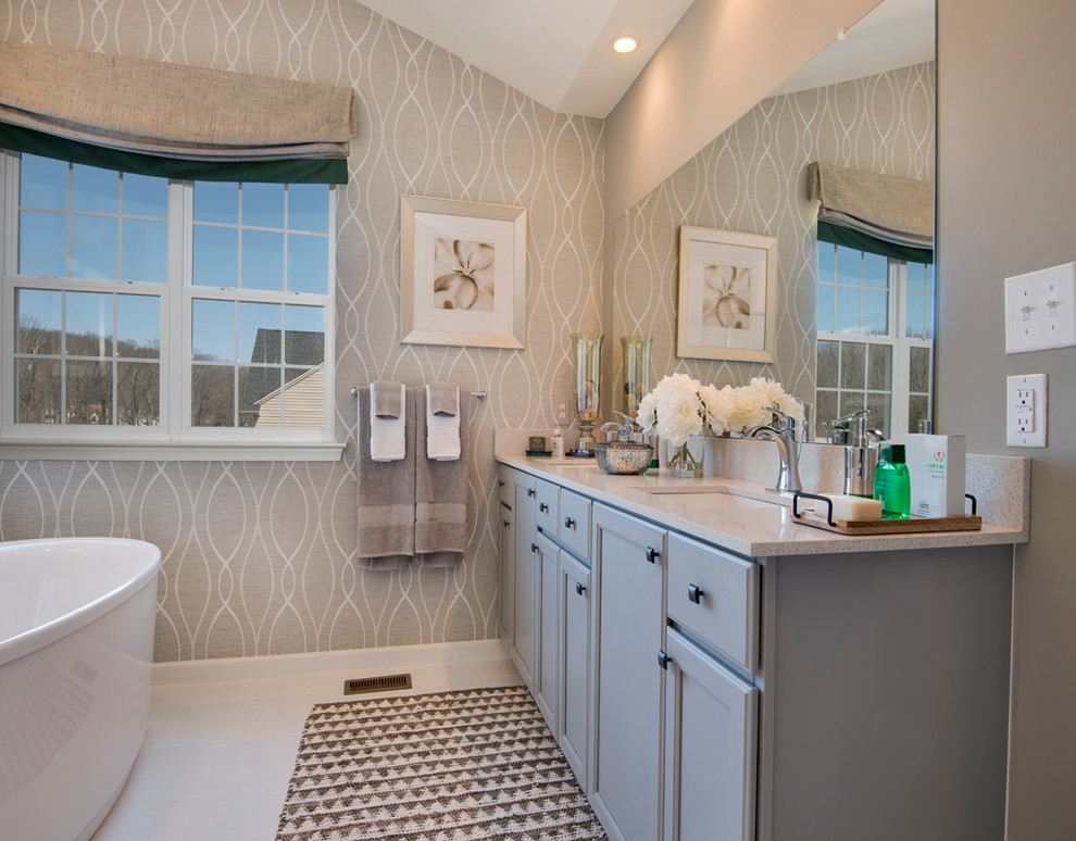 This is an example of a large traditional master bathroom in Philadelphia with flat-panel cabinets, grey cabinets, a freestanding tub, a double shower, a one-piece toilet, gray tile, porcelain tile, grey walls, porcelain floors, an undermount sink and granite benchtops.