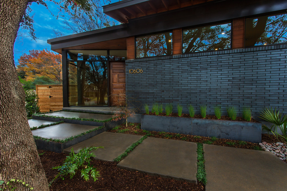 Design ideas for a mid-sized midcentury two-storey grey house exterior in Dallas with mixed siding and a metal roof.
