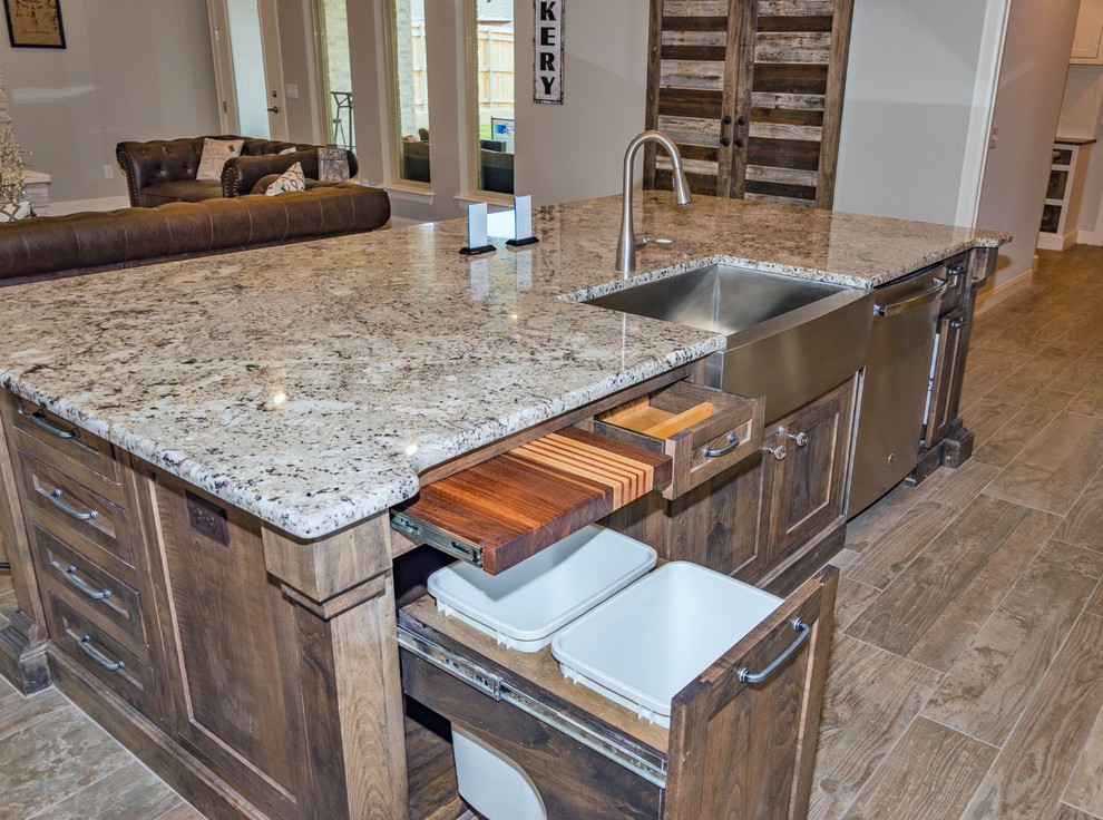 Inspiration for a large country l-shaped open plan kitchen in Dallas with a farmhouse sink, shaker cabinets, white cabinets, granite benchtops, grey splashback, stone tile splashback, stainless steel appliances, porcelain floors, with island and multi-coloured floor.