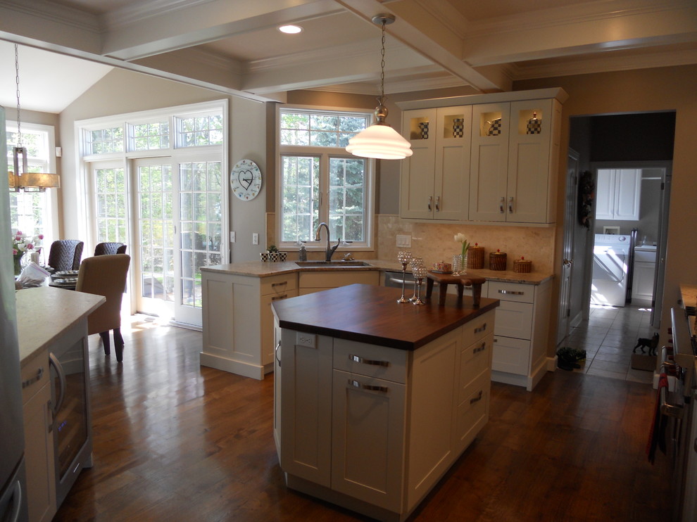 Eat-in kitchen - large transitional u-shaped medium tone wood floor eat-in kitchen idea in New York with an undermount sink, recessed-panel cabinets, white cabinets, granite countertops, multicolored backsplash, porcelain backsplash, stainless steel appliances, gray walls and an island