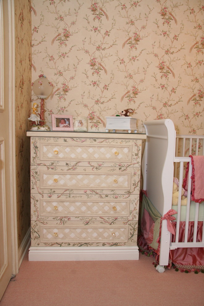 This is an example of a large traditional nursery for girls in New York with pink walls and carpet.