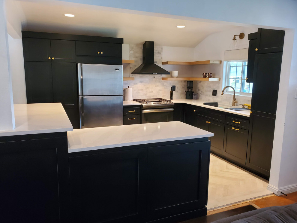 Photo of a mid-sized modern l-shaped kitchen in Los Angeles with a single-bowl sink, shaker cabinets, black cabinets, quartz benchtops, grey splashback, marble splashback, with island and white benchtop.