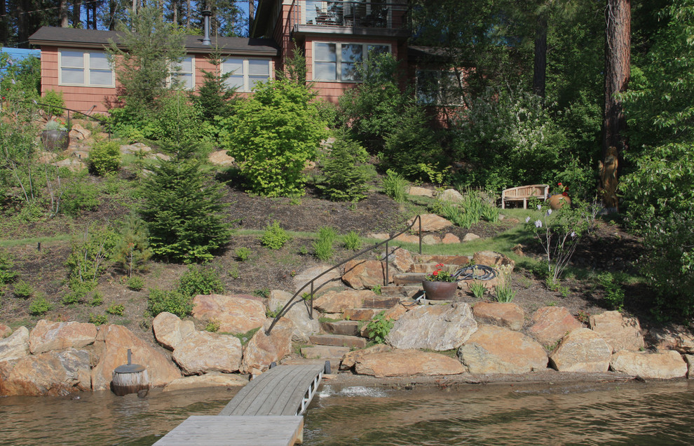 Inspiration for a mid-sized country sloped garden in Seattle with a retaining wall and natural stone pavers.