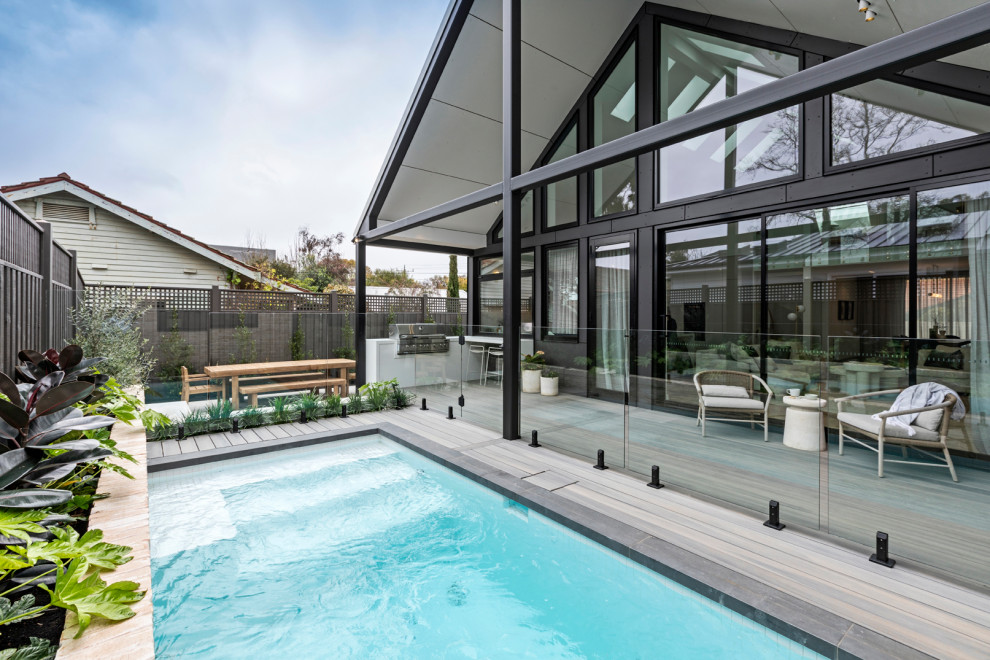 Idée de décoration pour un petit piscine avec aménagement paysager arrière design rectangle avec une terrasse en bois.