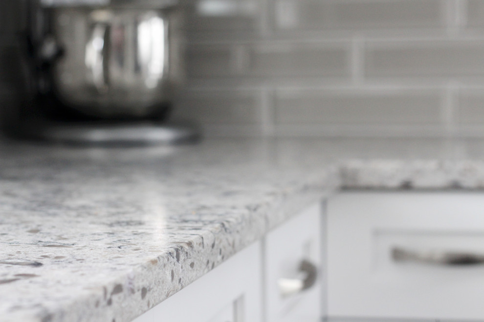 U-shaped kitchen photo with shaker cabinets, white cabinets, quartzite countertops, gray backsplash, subway tile backsplash, a peninsula and gray countertops