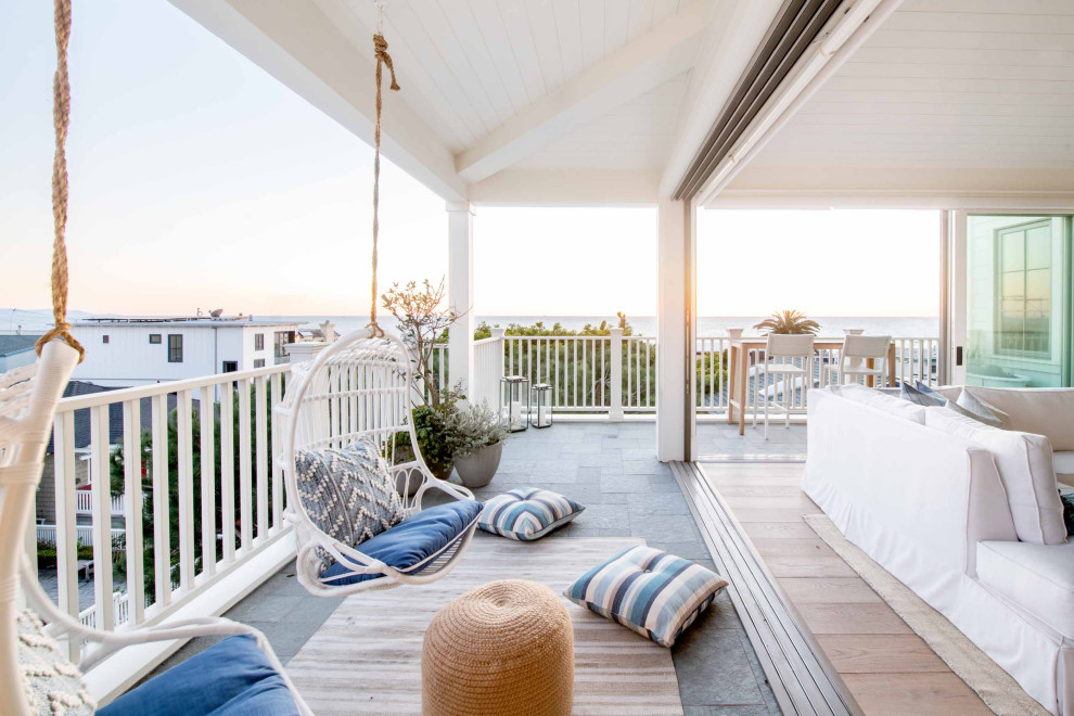 Design ideas for a beach style deck in Los Angeles with a roof extension.
