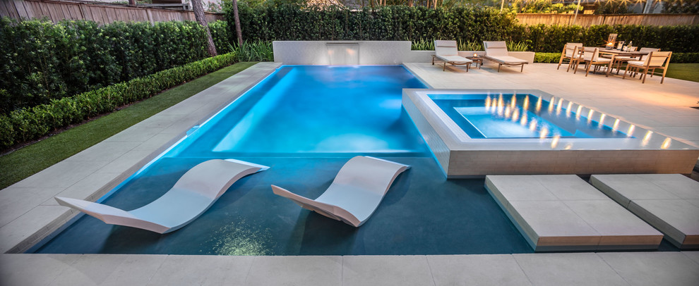 Design ideas for a small contemporary backyard rectangular infinity pool in Houston with a hot tub and tile.