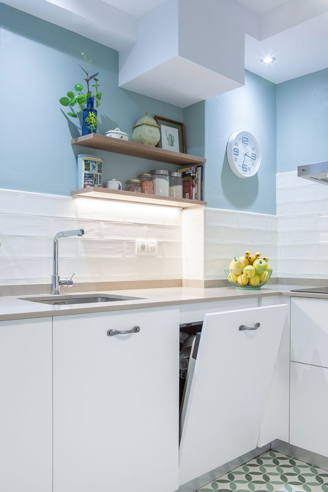 This is an example of a small contemporary l-shaped kitchen in Other with a single-bowl sink, flat-panel cabinets, white cabinets, stainless steel appliances, green floor and beige benchtop.