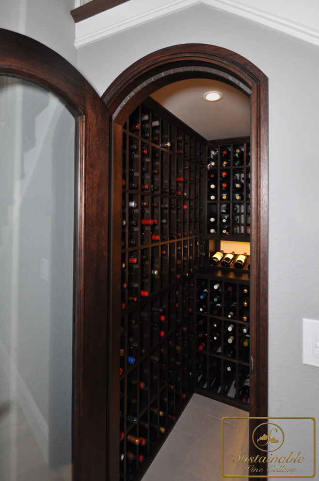 Small modern wine cellar in San Diego with porcelain floors and storage racks.