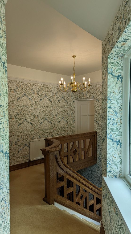 This is an example of a traditional staircase in Other with wallpaper.