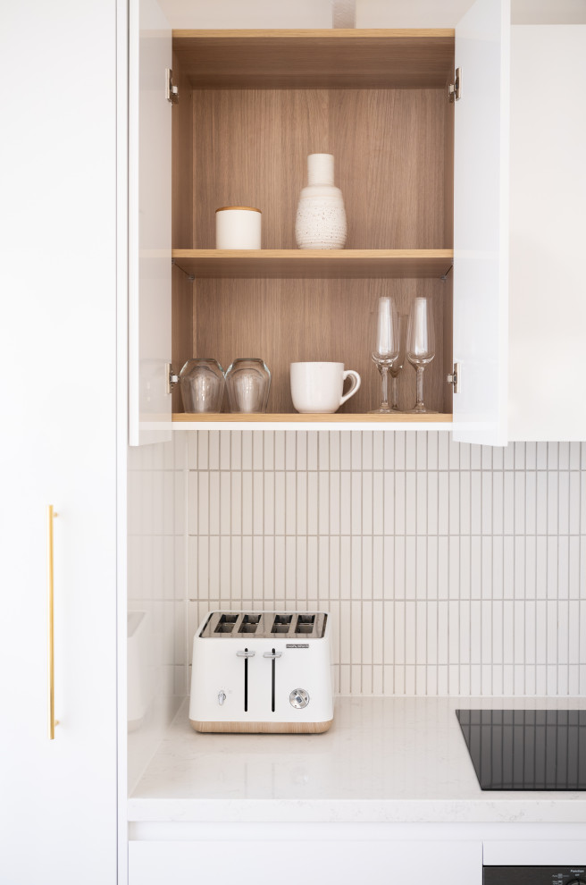 Example of a minimalist kitchen design in Sydney with white backsplash and ceramic backsplash