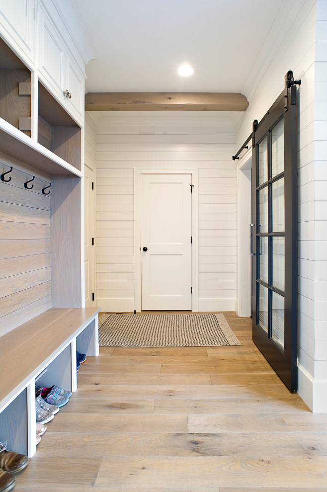 Design ideas for a country mudroom in Other with white walls, light hardwood floors and brown floor.