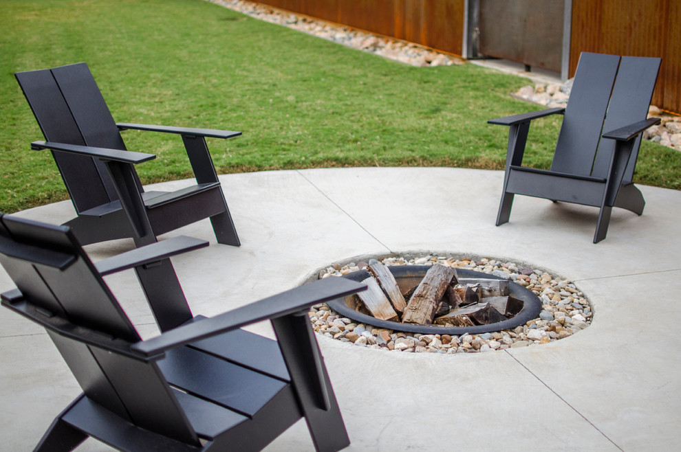 Small contemporary backyard patio in Dallas with a fire feature, concrete slab and no cover.