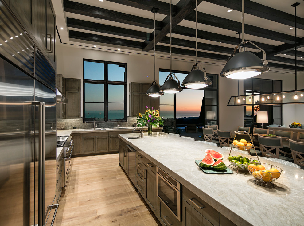 Large contemporary l-shaped open plan kitchen in Santa Barbara with an undermount sink, shaker cabinets, green cabinets, marble benchtops, stainless steel appliances, light hardwood floors and with island.