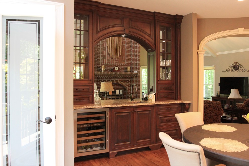 Design ideas for a mid-sized traditional single-wall wet bar with an undermount sink, beaded inset cabinets, dark wood cabinets, granite benchtops and medium hardwood floors.