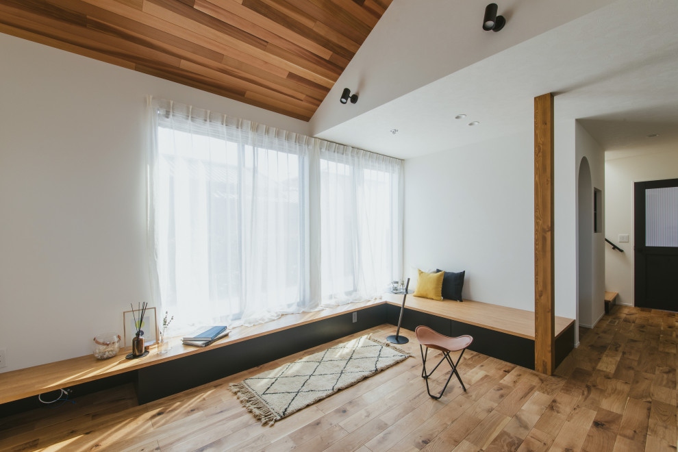 Foto di un soggiorno country con pareti bianche, pavimento in legno massello medio, TV a parete, pavimento marrone, soffitto in carta da parati e carta da parati
