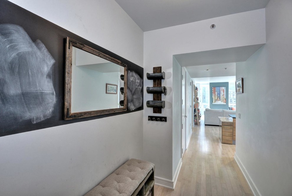 Photo of a small contemporary hallway in San Francisco with white walls and light hardwood floors.